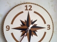 Orologio da parete decorativo con design a forma di rosa dei venti.