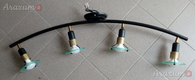 Lampada da soffitto con base curva nera e quattro punti luce.