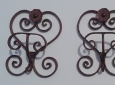 Appendiabiti in ferro battuto con volute decorative e un motivo floreale.